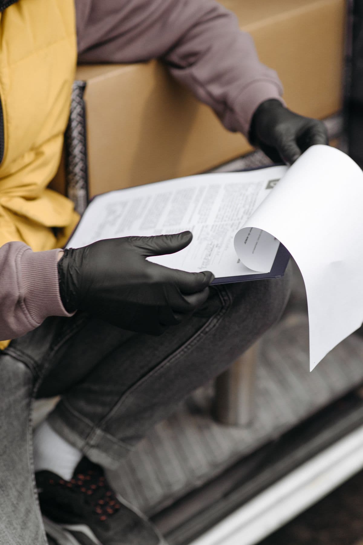 Courier checking delivery documents on a clipboard