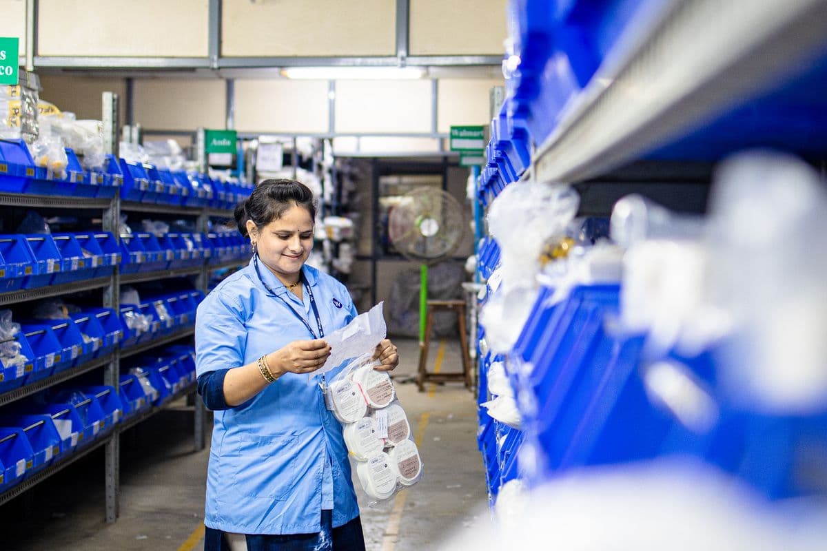 Worker organizing stock within warehouse shelving