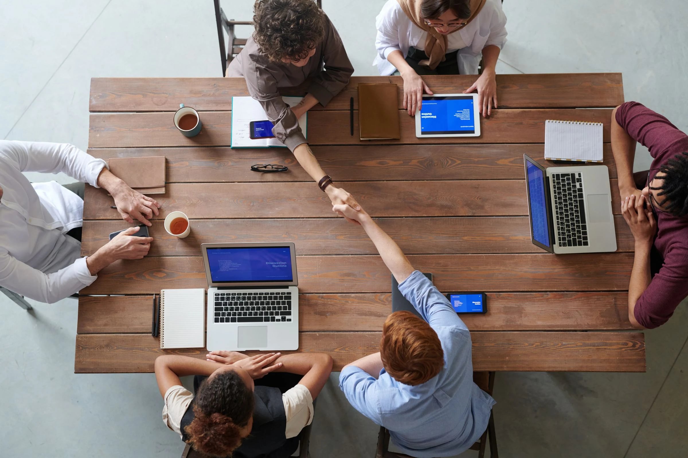 Colleagues reviewing a handoff around a shared worktable